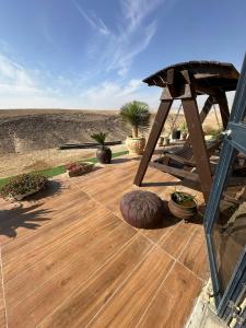 a wooden deck with a picnic table and potted plants at צימר בוטיק אדלה Zimmer boutique adela in Arad