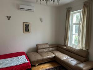 a living room with a couch and a window at Giulia Vendégház in Balatonboglár +2 photos