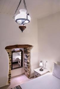 a bedroom with a stone fireplace and a chandelier at Feneri- cozy Apartment 20' from Elafonisi beach in Elafonisi