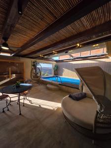 a room with a swimming pool with a couch and a table at צימר בוטיק אדלה Zimmer boutique adela in Arad