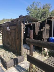 a wooden fence with a wooden door in a field at Cabane insolite au sein d un ranch in Poilhès