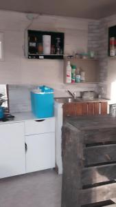 a kitchen with white cabinets and a blue box on the counter at Cabane insolite au sein d un ranch in Poilhès