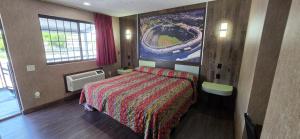 a hotel room with a bed and a picture of a baseball game at South Bay Motel in Copiague