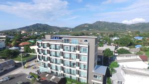 a building in a city with mountains in the background at The Elysium Residence - SHA Extra Plus in Chalong 