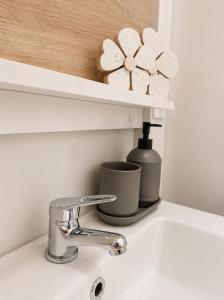 a sink with a faucet and a cup on it at Hiška Gaia- pool tickets included in Brežice +5 photos