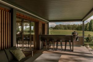 a screened in porch with a table and chairs at Lėtai resort, Lakefront Nature Stay with Sauna in Eželiškės