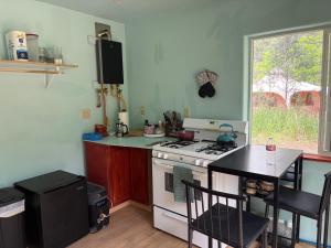 a kitchen with a stove and a table and a window at Pagosa Chi Camps in Pagosa Springs