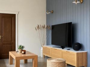 ein Wohnzimmer mit einem Flachbildfernseher auf einem Holzschrank in der Unterkunft Spithami Pool House in Spithami