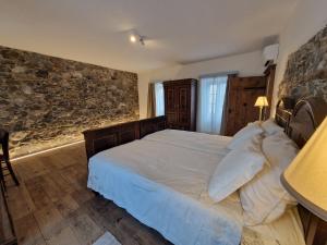 a bedroom with a bed and a stone wall at Vila Dobra in Dobravlje