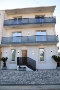a large white building with a balcony on it at Darius Hotel in Shkodër