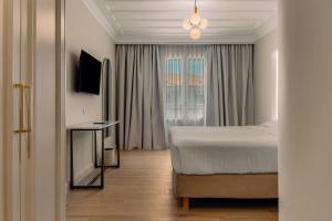 a hotel room with a bed and a window at Royal Nidri Suites in Nydri