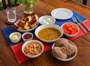 a table with bowls of food on a wooden table at Vercour Tree House Cabana Sigiriya in Sigiriya