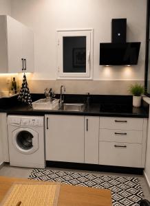 a kitchen with a sink and a washing machine at Blueyes in Tunis