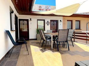 a patio with a table and chairs on a deck at Gyulai idill apartman in Gyula