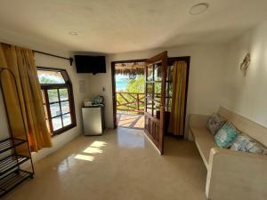 a living room with a couch and an open door at Hotelito Crismi in Holbox Island