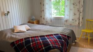 a bedroom with a bed with a pillow and a window at Karjalan Helmi in Tolosenmäki