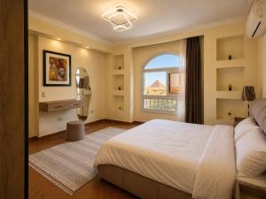 a bedroom with a large bed and a window at NOVA GATE Panorama Pyramids Suite in Giza