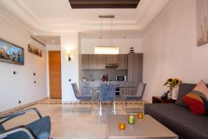 a living room with a couch and a table at Appartement Au vizir avec Accès au Parc de loisirs in Dar Caïd Layadi