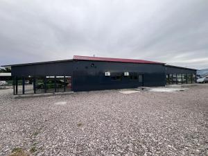a black building with a red roof and a parking lot at Motobike Experience in Arkos
