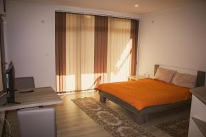 a bedroom with a bed and a desk and a window at Stara Charshija - Old Bazaar in Bitola