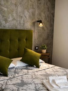 a bedroom with a bed with a green headboard at Affitti Brevi SCALA DEI TURCHI in Realmonte