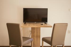 a flat screen tv sitting on a table with two chairs at Stara Charshija - Old Bazaar in Bitola