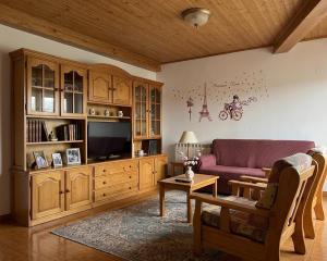 a living room with a couch and a tv at Apartamentos El Cuetu in Llanes