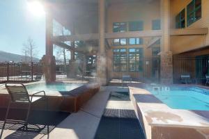 a building with a swimming pool in front of a building at Silver Lodge A in Granby