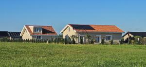 a house with solar panels on its roof in a field at 3 ruoniai in Palanga