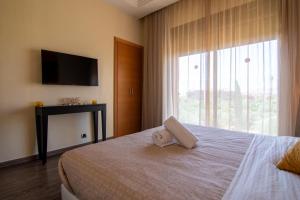 a bedroom with a bed with a towel on it at Appartement Au vizir avec Accès au Parc de loisirs in Dar Caïd Layadi +20 photos
