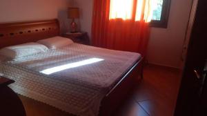 a bedroom with a bed with the sun shining through a window at Villa Alois in Konispol