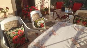 two white chairs with a table and a table with flowers at Villa Alois in Konispol