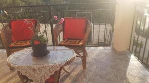 a balcony with two chairs and a table with a vase at Villa Alois in Konispol