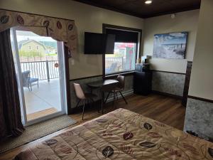 a hotel room with a bed and a balcony at Manoir sur Mer in Sainte-Anne-des-Monts