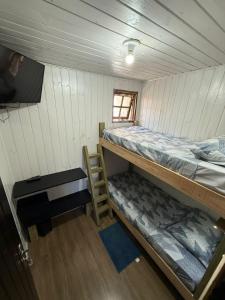 a small room with two bunk beds and a television at HOSTEL FAMILIA ZANATTA in Caxias do Sul +50 photos