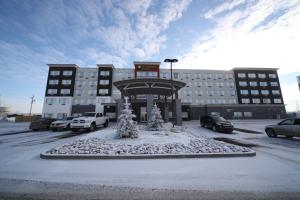 a parking lot with a clock in front of a building at Wyndham Garden Edmonton Airport in Leduc