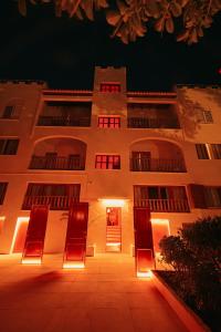 a building with chairs in front of it at night at The Ibiza Oasis - Adults Only - Secret Suites in San Antonio Bay +98 photos