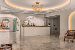 a lobby with a reception desk and a chandelier at Royal Nidri Suites in Nydri +56 photos