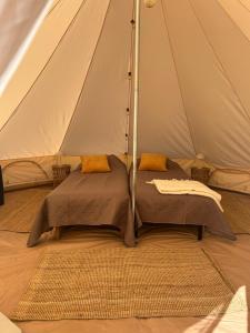a tent with a bed and a rug in it at Glamping Arctic Ukuli in Rovaniemi +23 photos