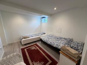 a bedroom with two beds and a rug at Spacy flat with big garden in Södertälje