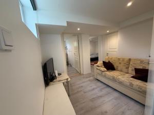 a living room with a couch and a television at Spacy flat with big garden in Södertälje