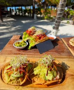 a wooden cutting board with tacos and salad on it at Hotelito Crismi in Holbox Island