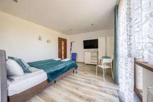 a bedroom with a bed and a table in a room at Domki letniskowe i pokoje u Katarzyny in Ustronie Morskie