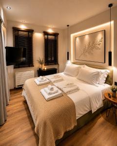 a bedroom with a large bed with towels on it at Aje Villas 1959 in Ioannina +65 photos
