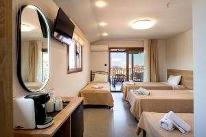 a hotel room with two beds and a mirror at Villa N&D in Ierissos