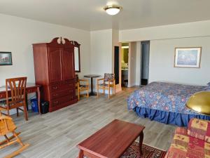 a bedroom with a bed and a desk and a table at Auberge Cap Martin in La Pocatiere +16 photos