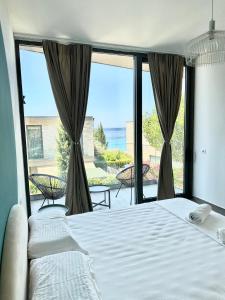 a bedroom with a bed and a view of the ocean at Sea't La Vie Villas in Hamallë
