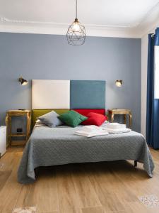 a bedroom with a large bed with colorful pillows at Affitti Brevi SCALA DEI TURCHI in Realmonte +2 photos