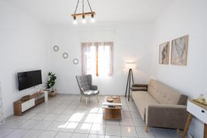 a living room with a couch and a tv at Anemoessa in Ammoudia