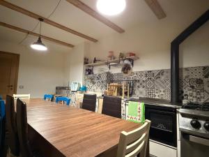 a kitchen with a long wooden table and chairs at B&B Scarpo & Supel in Nona